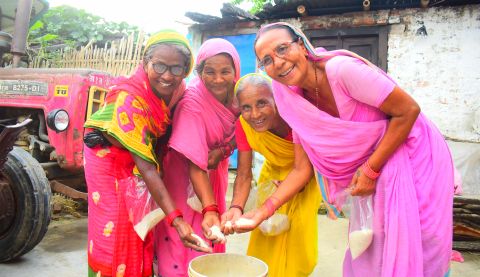 Women's groups in Nepal collect rice to help families in need.