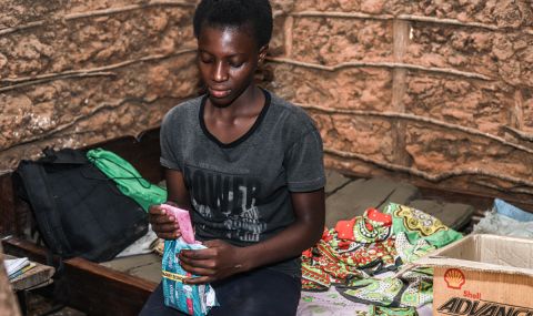 Margaret, 15, from Kenya, opens a dignity kit she received from ActionAid. It includes period products and other essentials.
