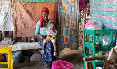 Woman sitting in a cafeteria in Ethiopia with a child on her lap