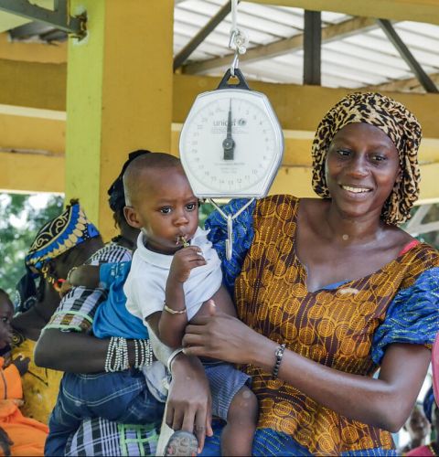 A nursing mother takes her child to a health centre in The Gambia.