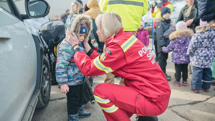 Romanian firefighter helping a Ukrainian child on the border with Romania 